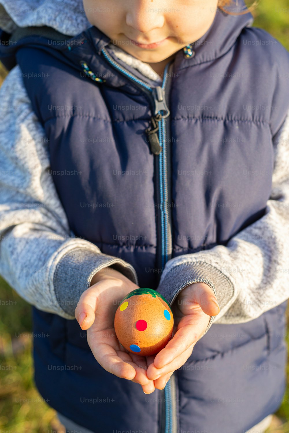 a little boy holding a ball in his hands