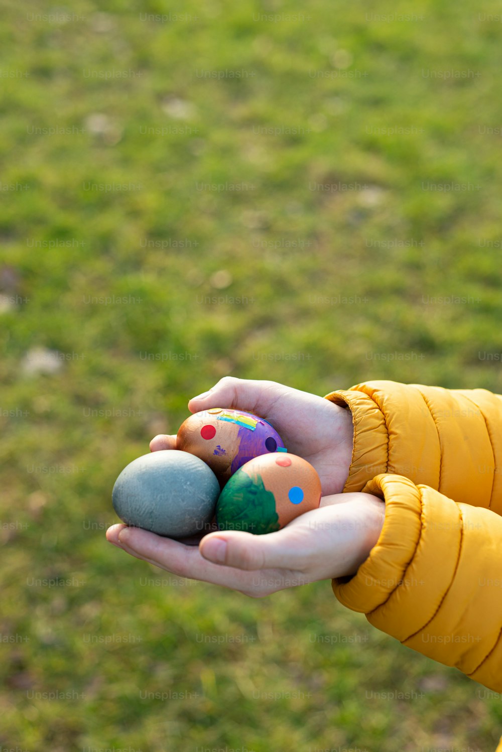 a person in a yellow jacket holding a bunch of eggs