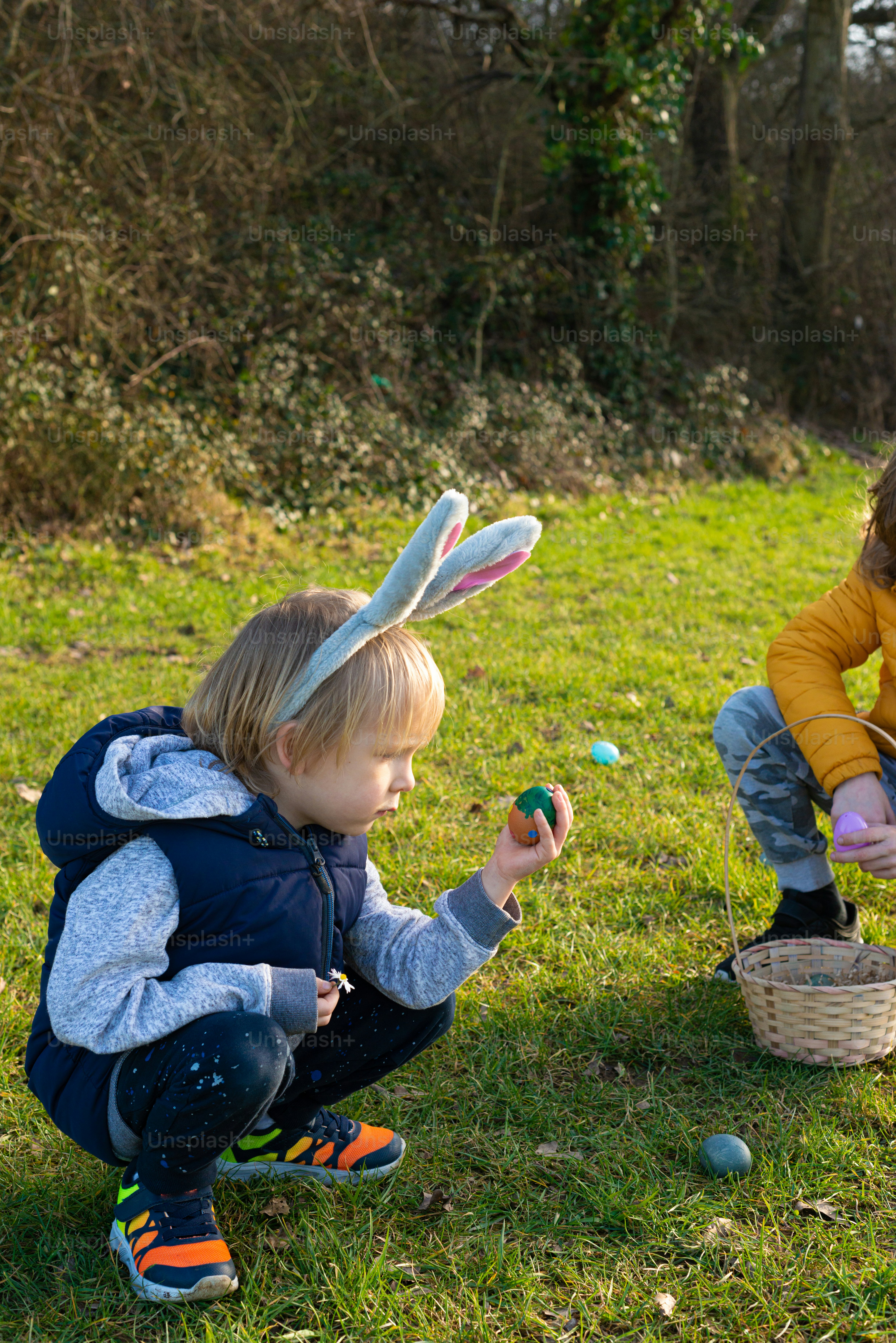 Deux enfants jouant avec des œufs de Pâques dans l’herbe
