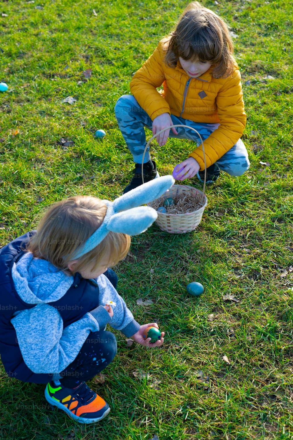 two young children playing with an easter basket