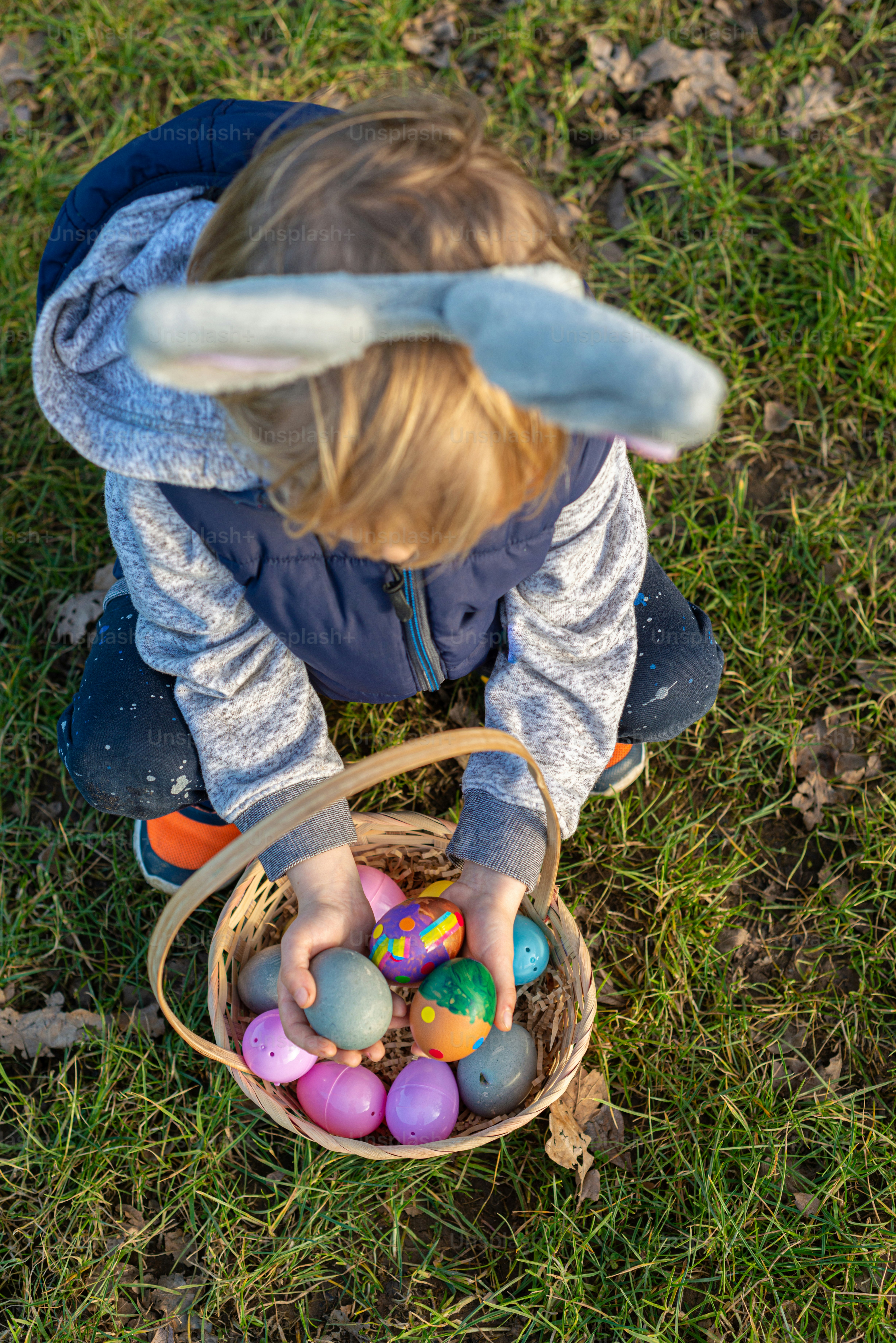 a little boy playing with a basket of eggs