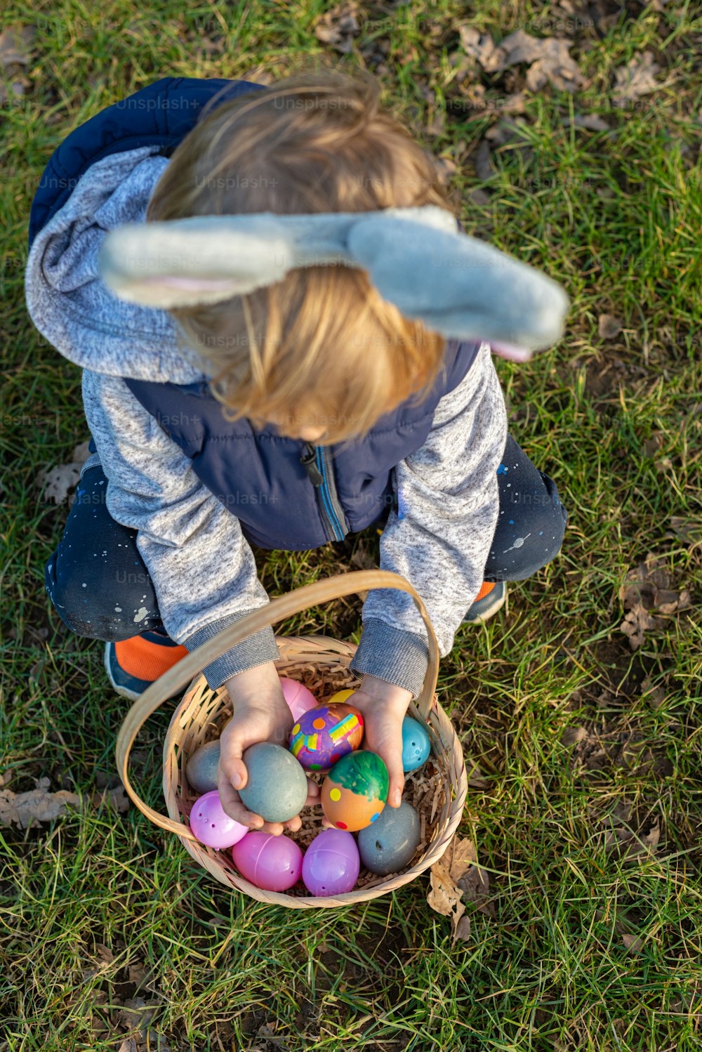 a little boy playing with a basket of eggs