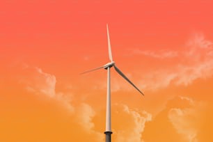 a wind turbine against a bright orange sky