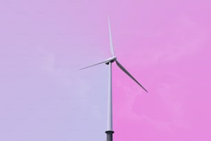 a wind turbine against a pink sky