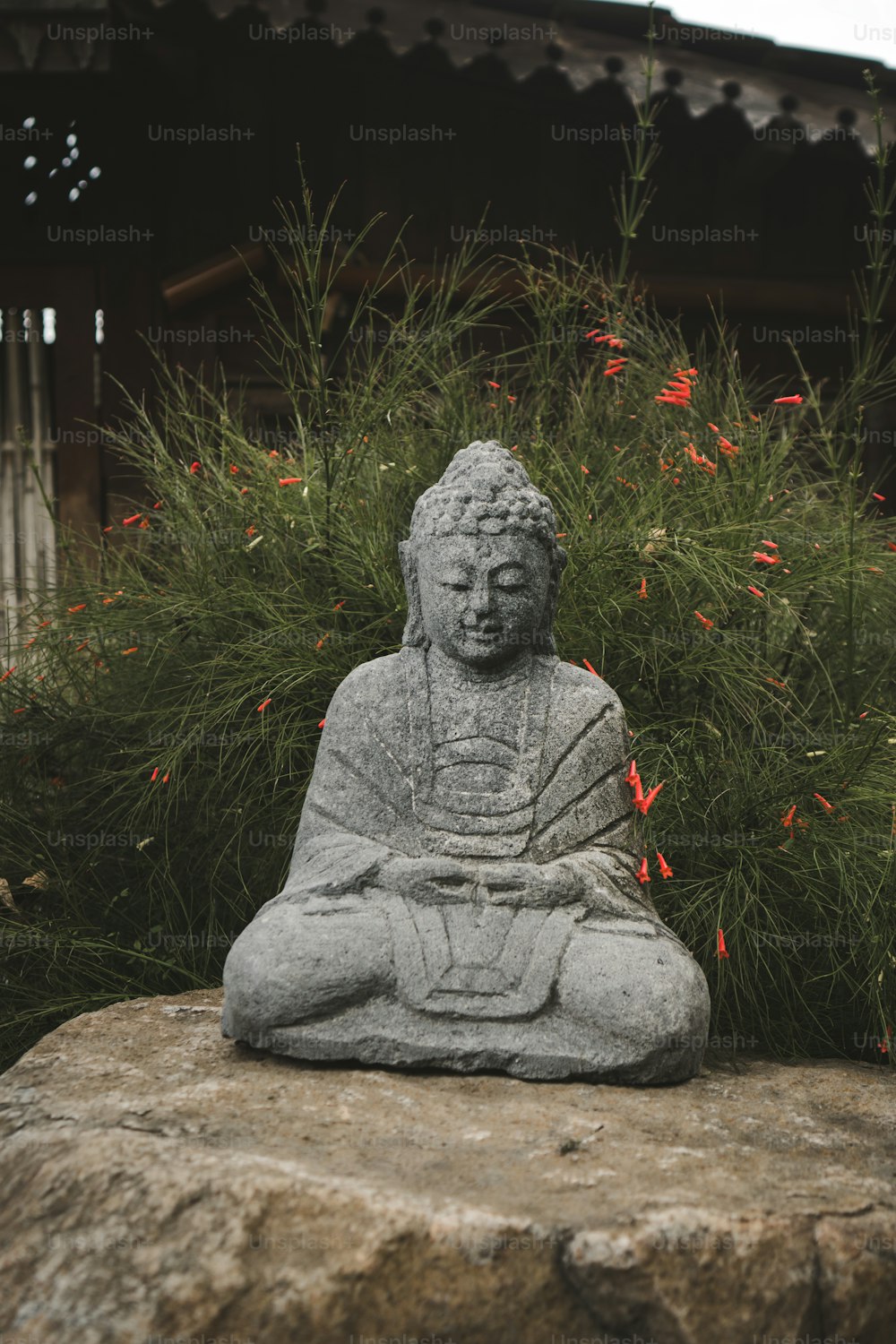 a buddha statue sitting on top of a rock