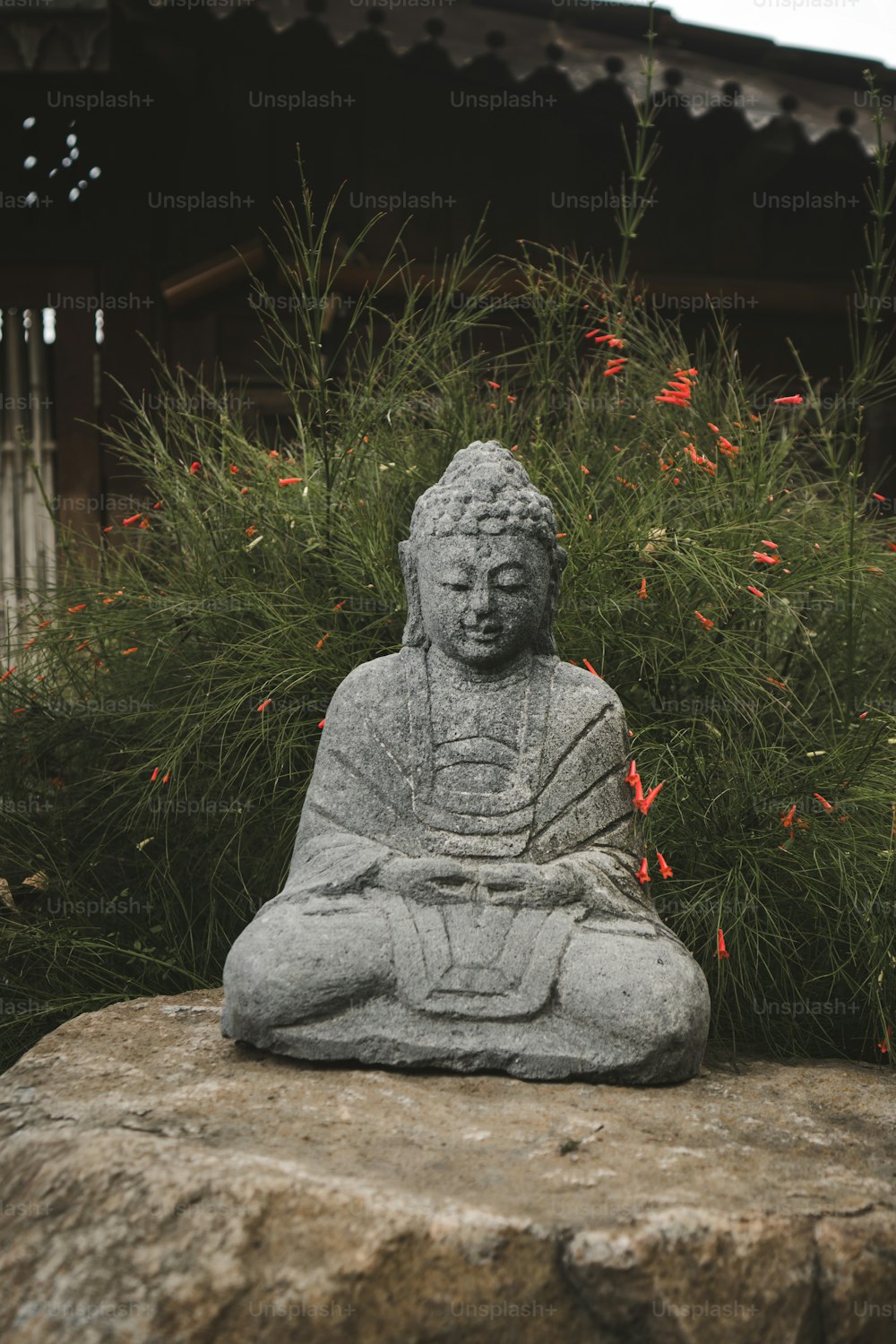 a buddha statue sitting on top of a rock