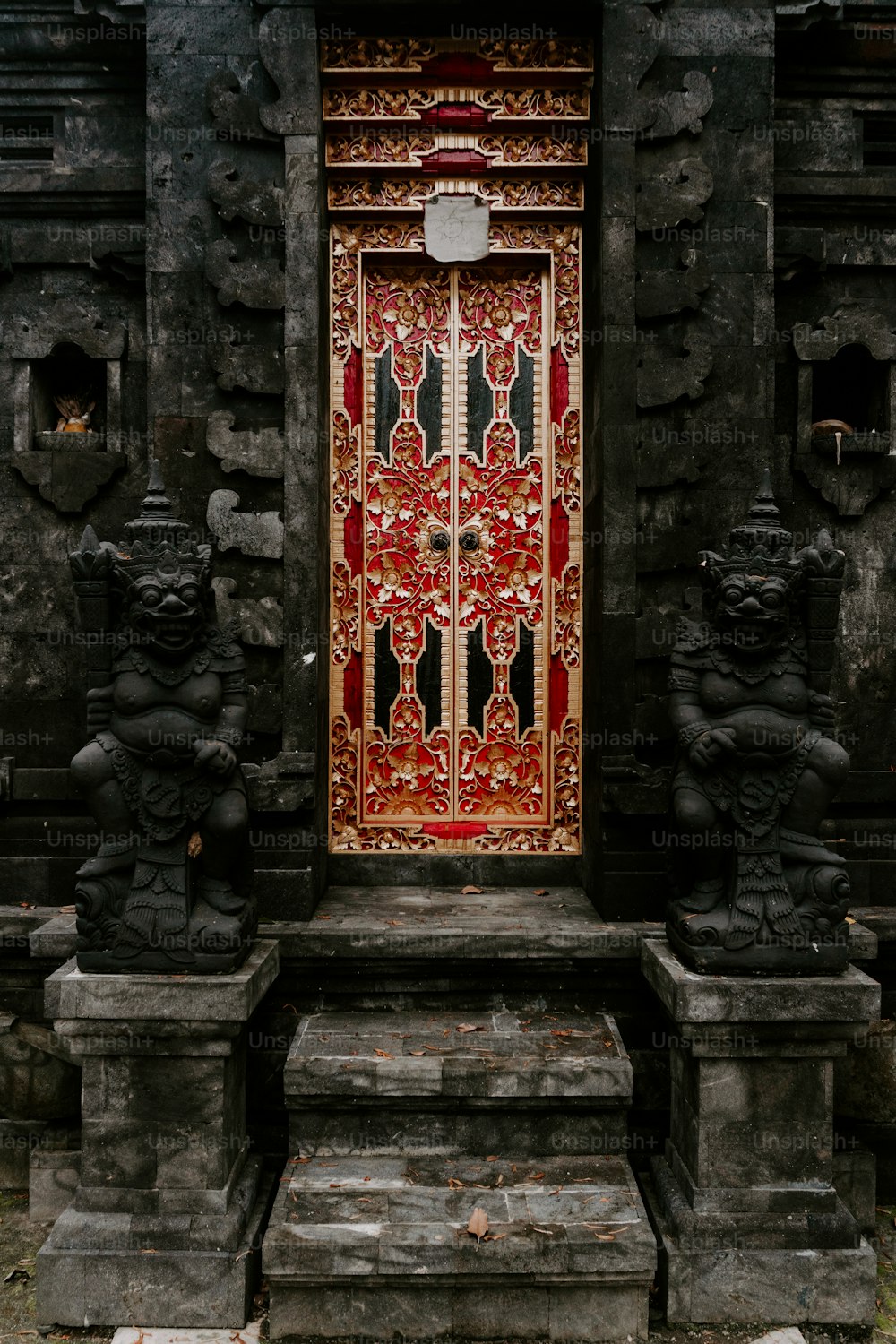 a red and gold door in a stone building