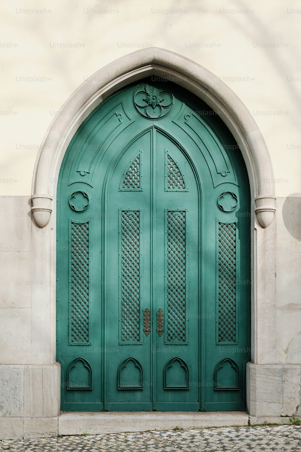 uma porta verde com um arco decorativo acima dela