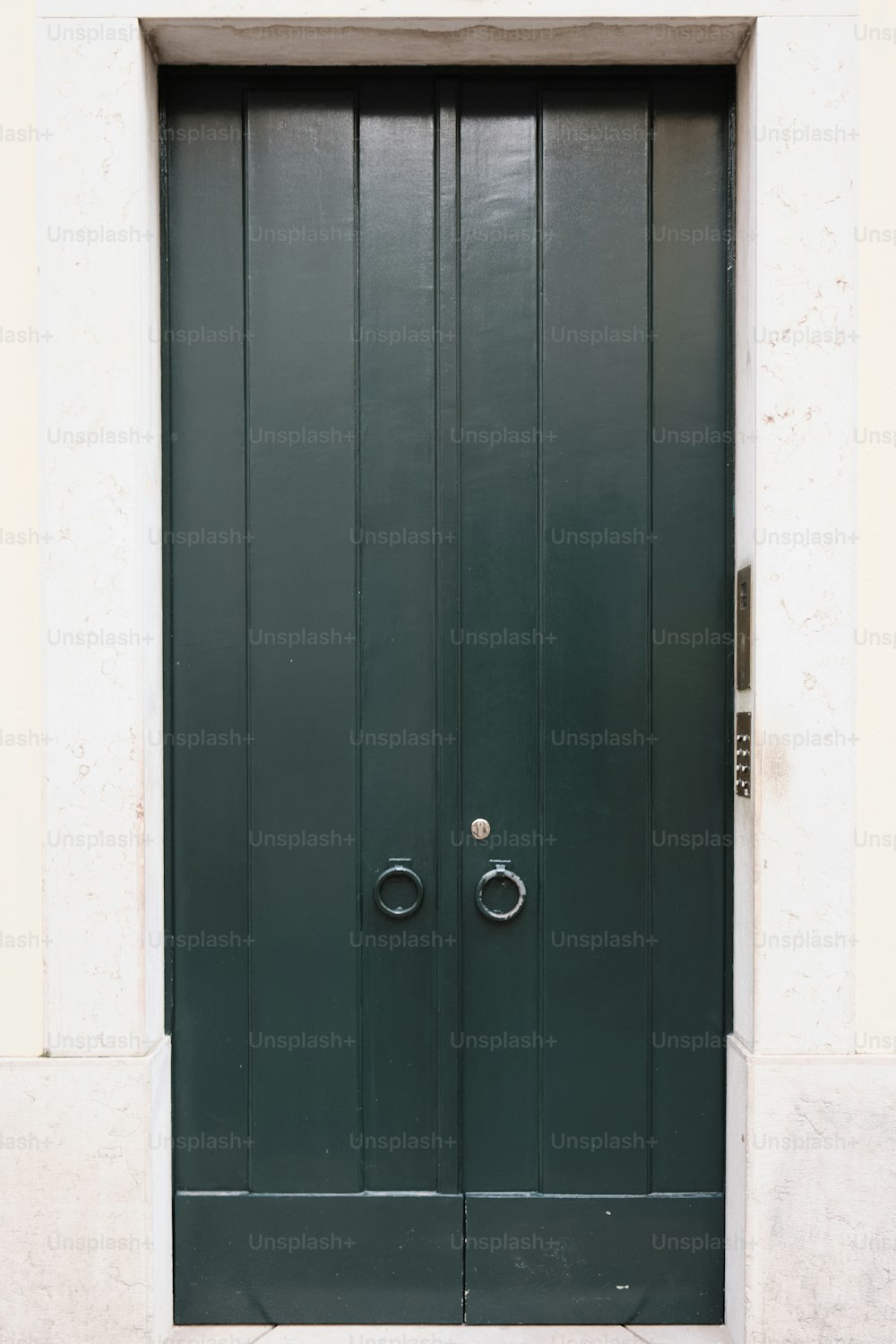 uma porta verde com duas maçanetas redondas sobre ela