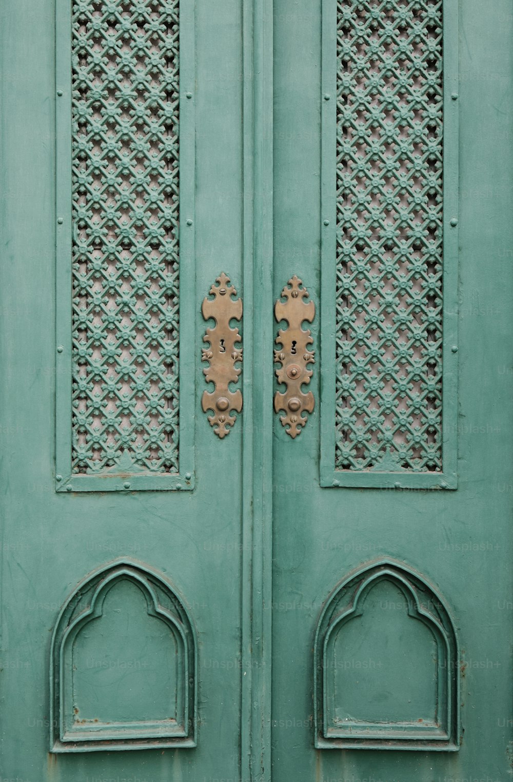 um close up de uma porta verde com desenhos ornamentados