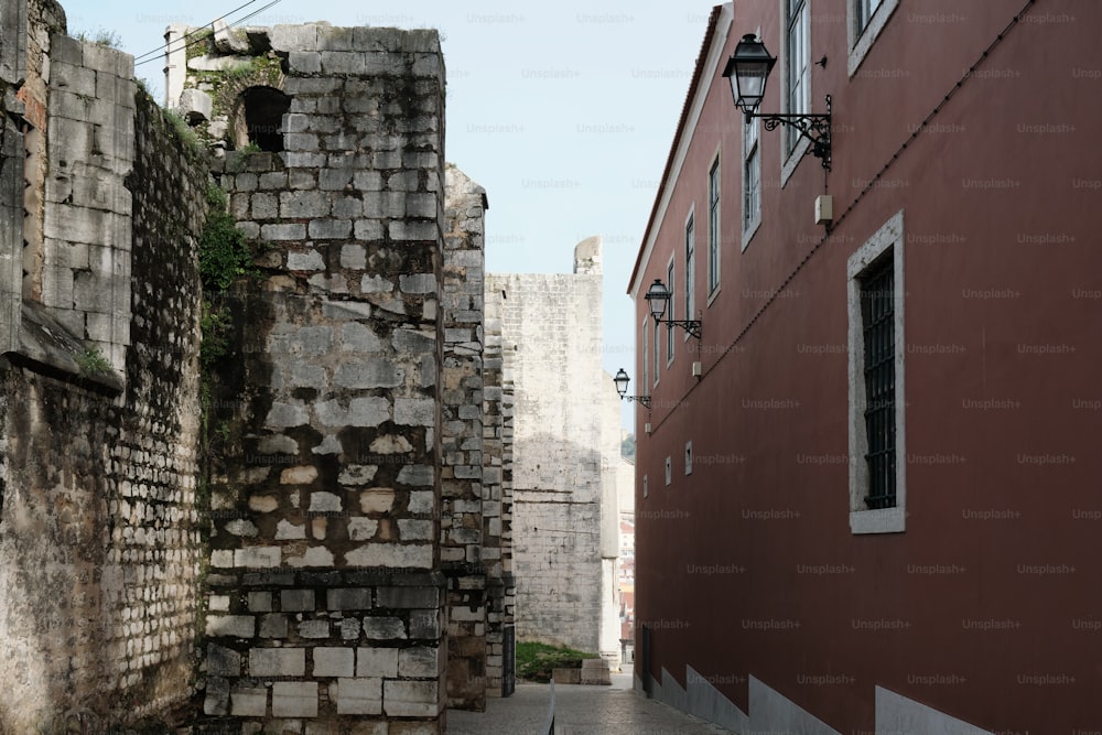 une ruelle avec un mur de briques et un lampadaire