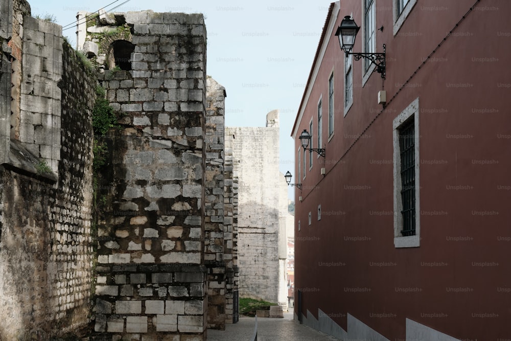 an alley way with a brick wall and a lamp post