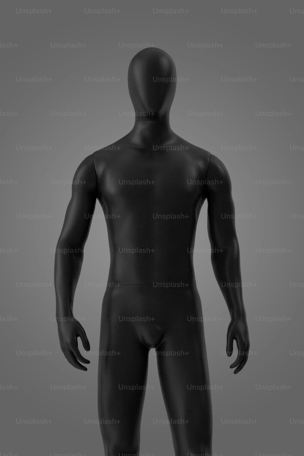 un manichino nero in piedi davanti a uno sfondo grigio