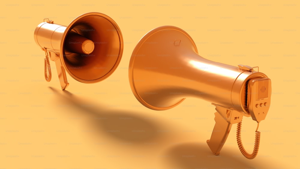 ein goldenes Megaphon und ein goldener Lautsprecher auf gelbem Grund