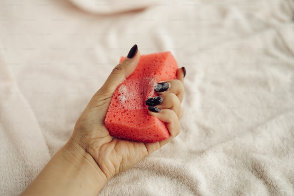 a woman's hand holding a piece of watermelon