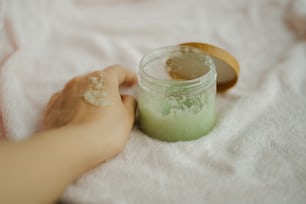 a person holding a jar of green powder