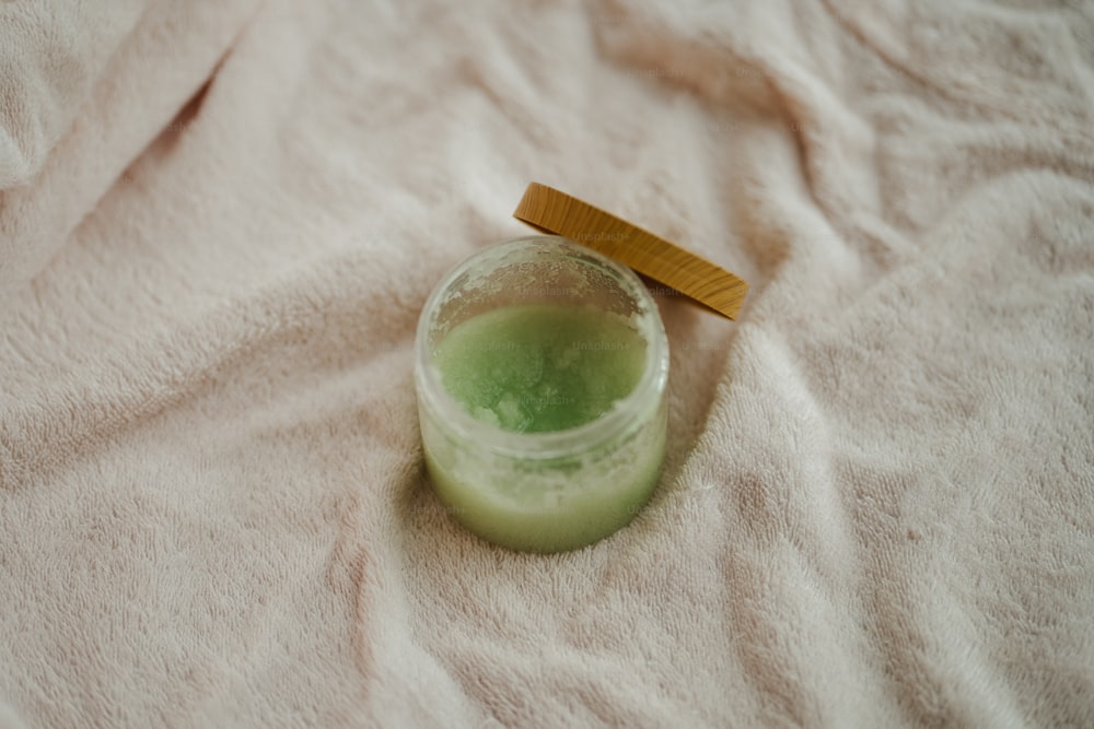 a green liquid in a glass with a wooden lid