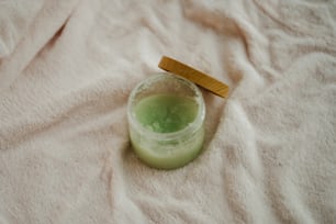 a green liquid in a glass with a wooden lid