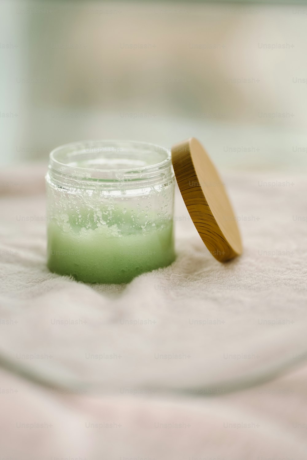 a jar of green liquid with a wooden lid