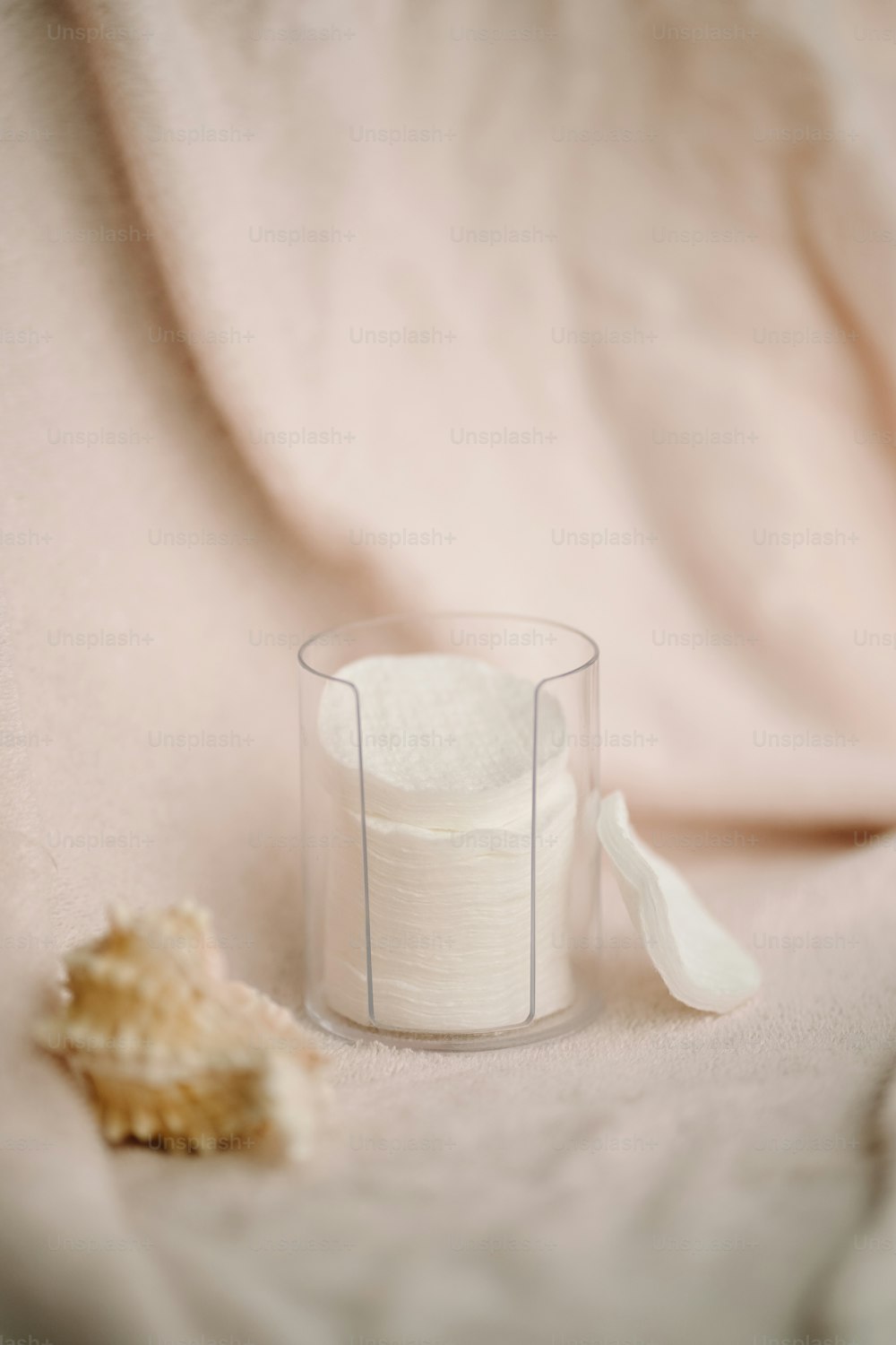 a white cloth and a glass on a bed
