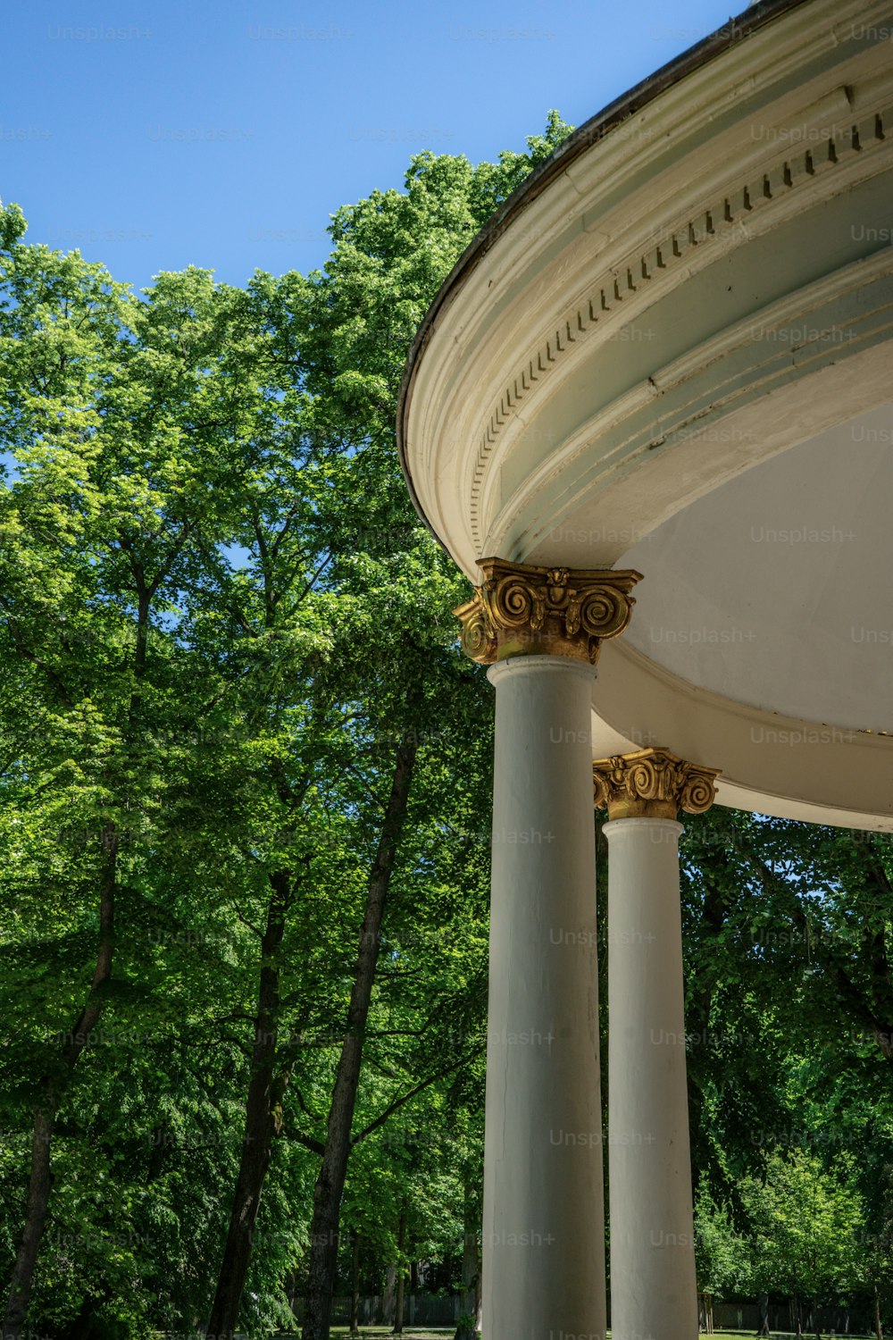 a gazebo in a park with trees in the background