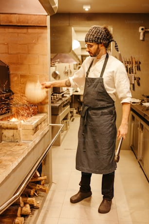 a man in an apron is cooking in a kitchen