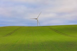 Eine Windkraftanlage auf einem grünen Hügel