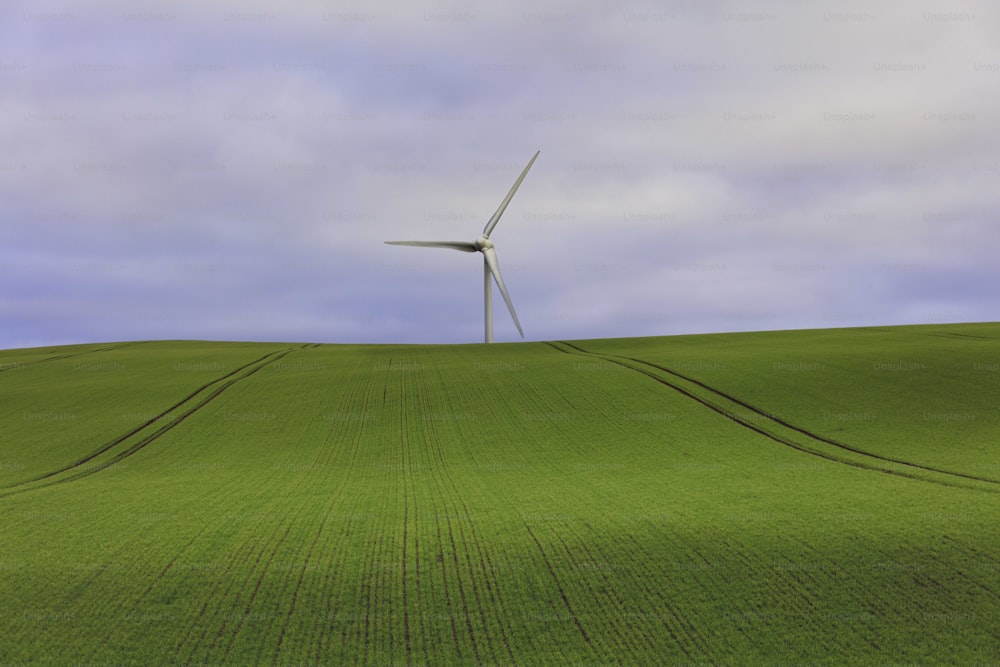 Eine Windkraftanlage auf einem grünen Hügel