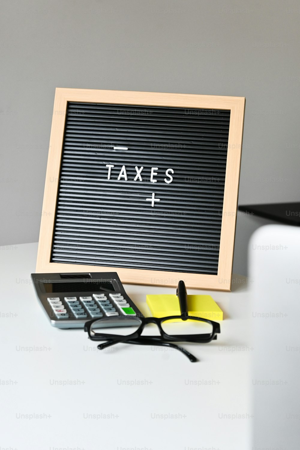 Un letrero que dice impuestos junto a un par de gafas