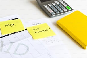 계산기 옆 책상 위에 놓인 노란색 스티커 메모