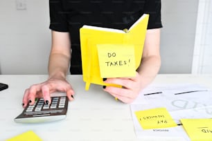 a person sitting at a desk with a calculator