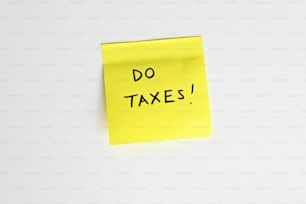 a sticky note with the words do taxes written on it