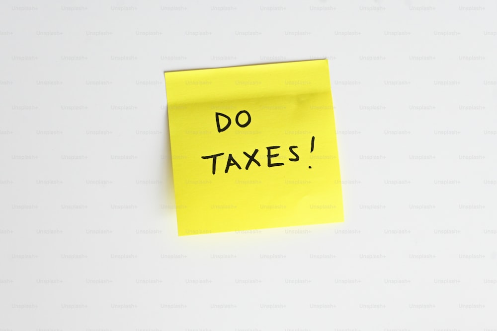 a sticky note with the words do taxes written on it