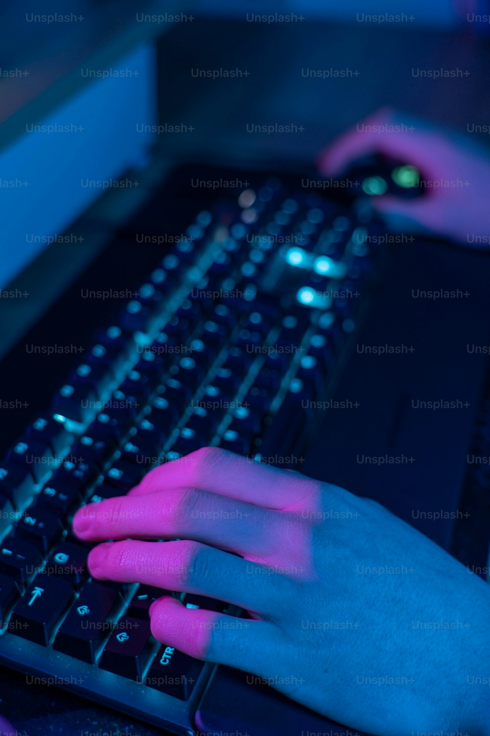 a person typing on a computer keyboard at night