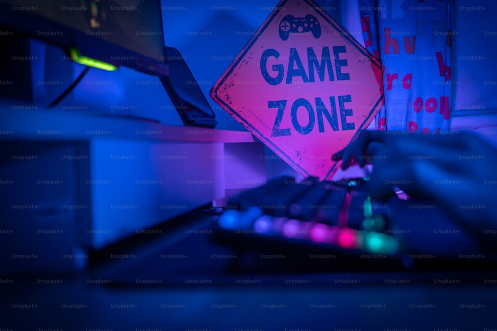 a game zone sign sitting on top of a computer desk