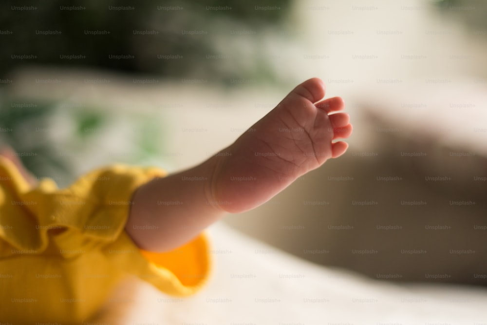 a close up of a baby's foot on a bed