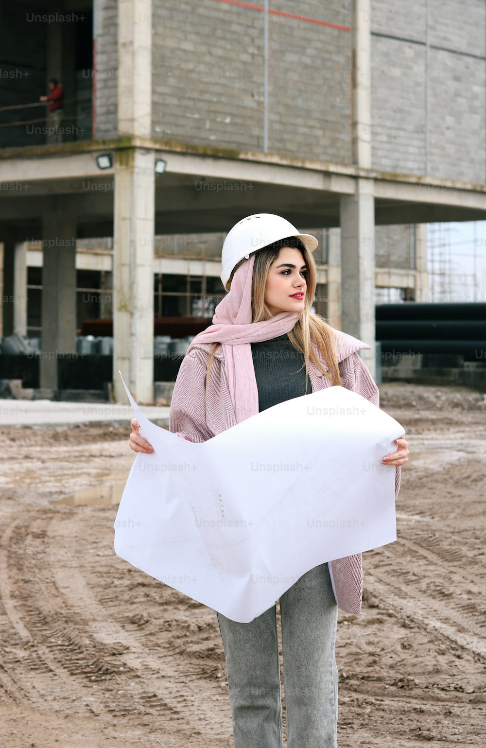Una mujer sosteniendo un pedazo de papel frente a un edificio
