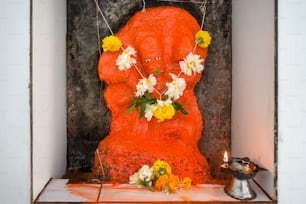 une statue d’un homme avec des fleurs autour du cou