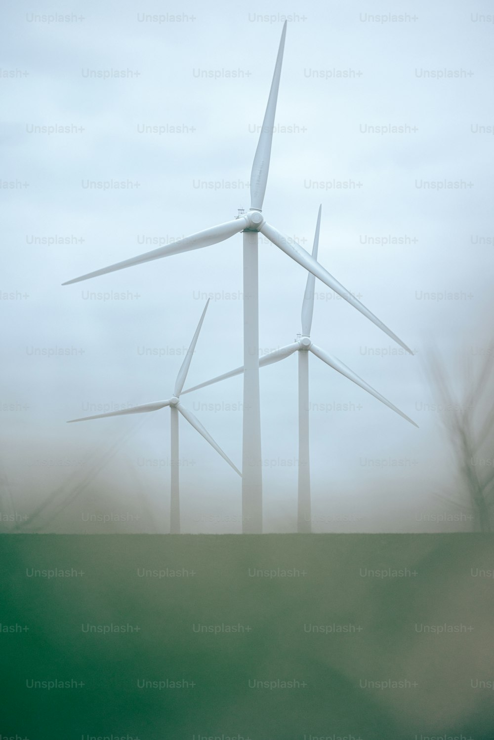 a group of wind turbines on a foggy day
