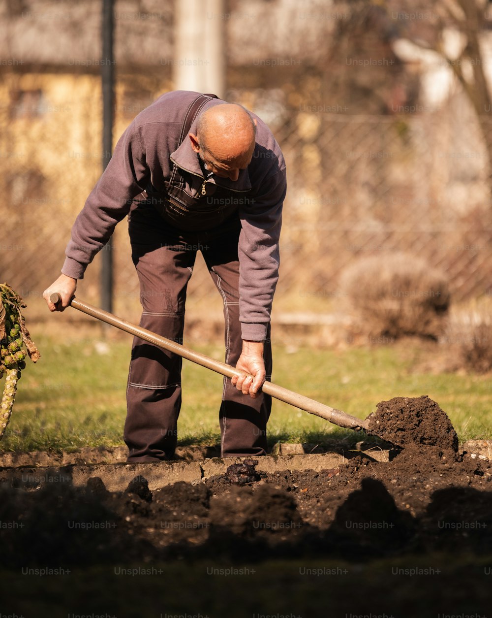 a man is digging in the dirt with a shovel