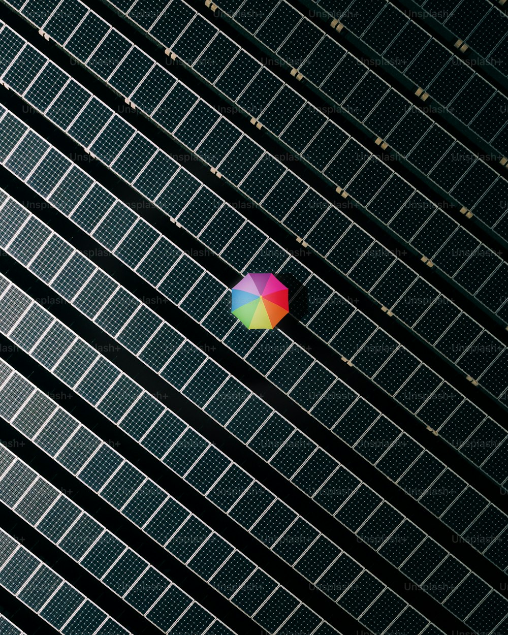 a colorful umbrella sitting on top of a solar panel