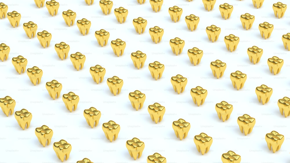 a large group of gold objects on a white surface