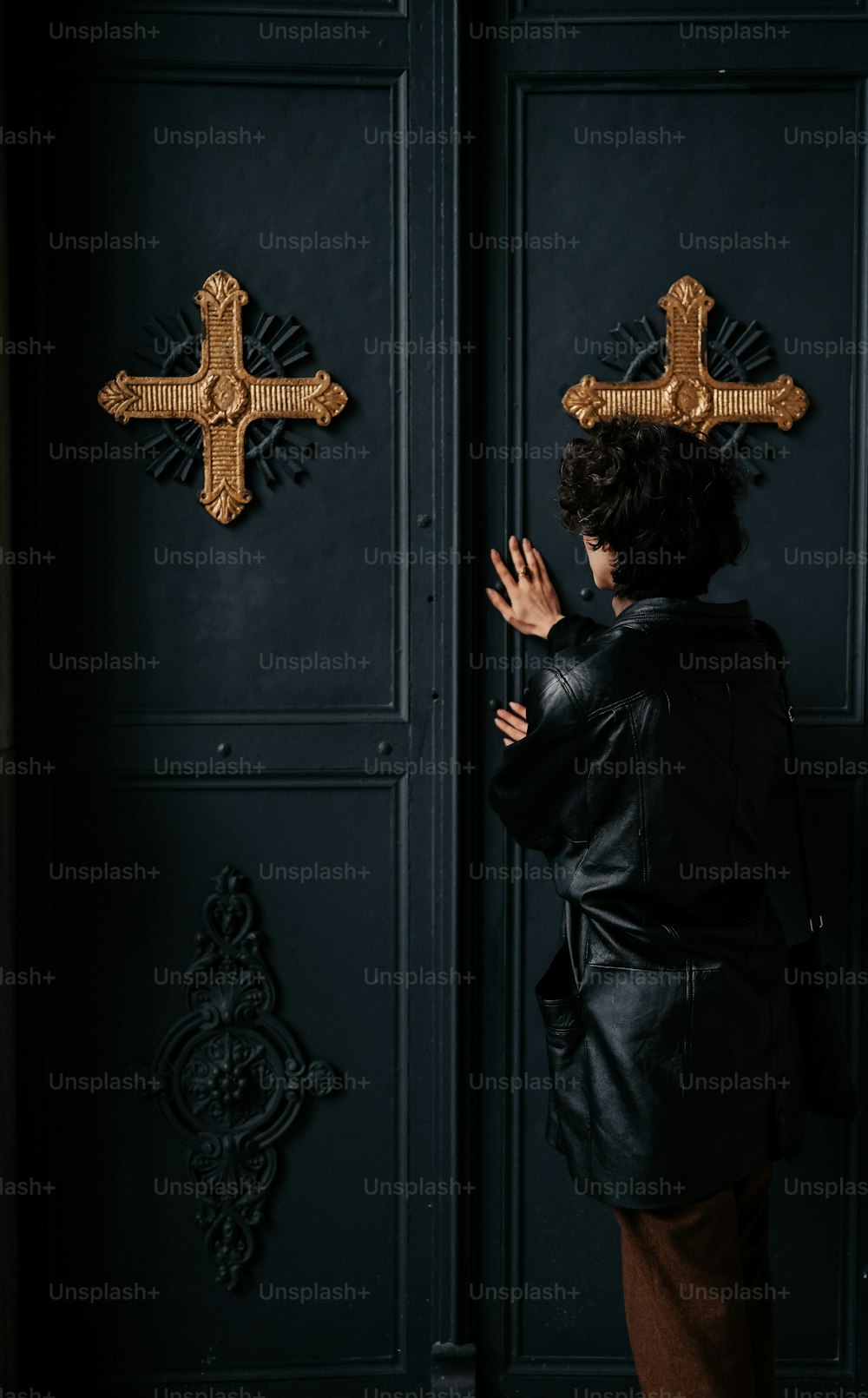 a woman standing in front of a black door