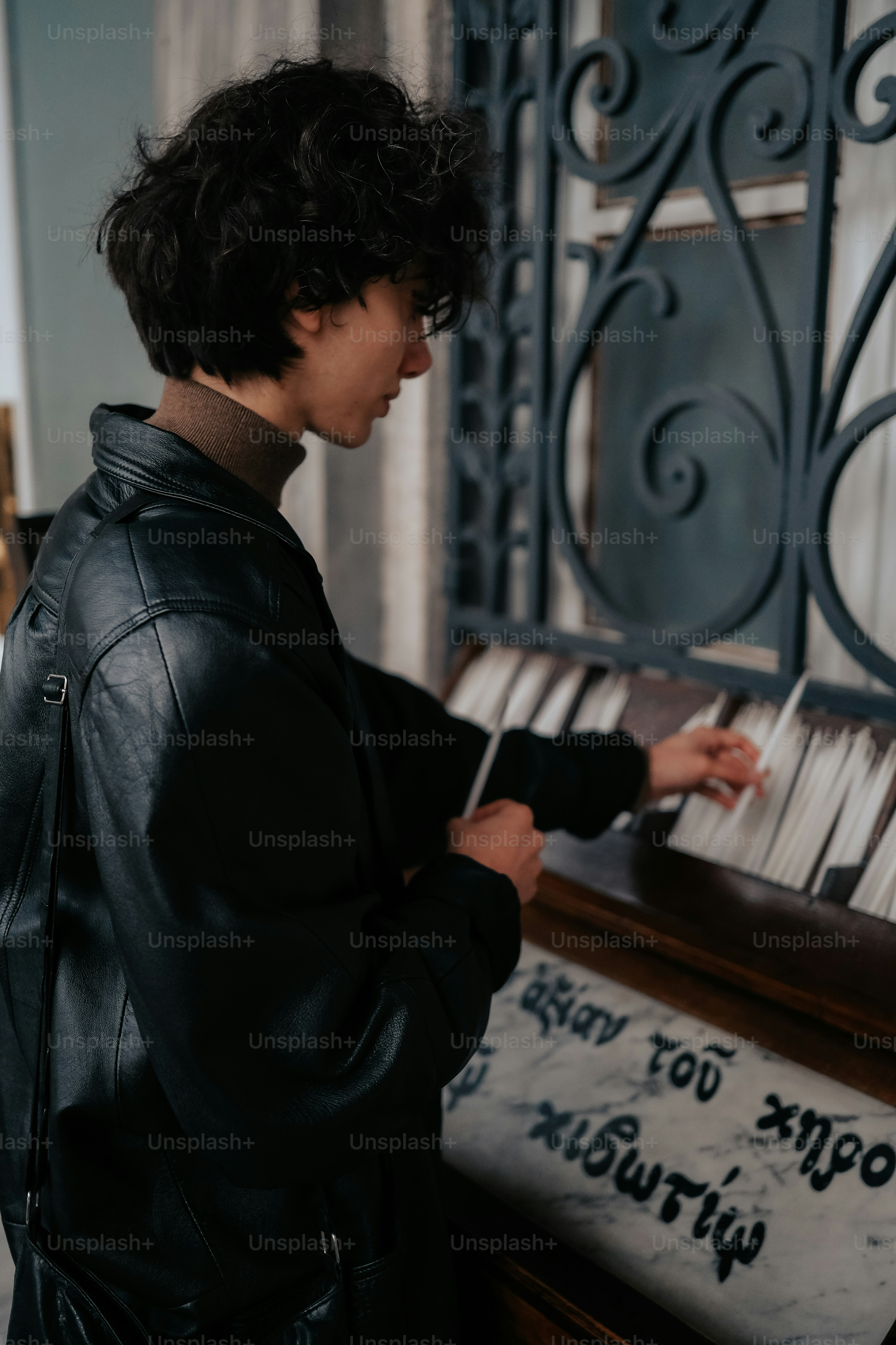a man in a black jacket playing a piano