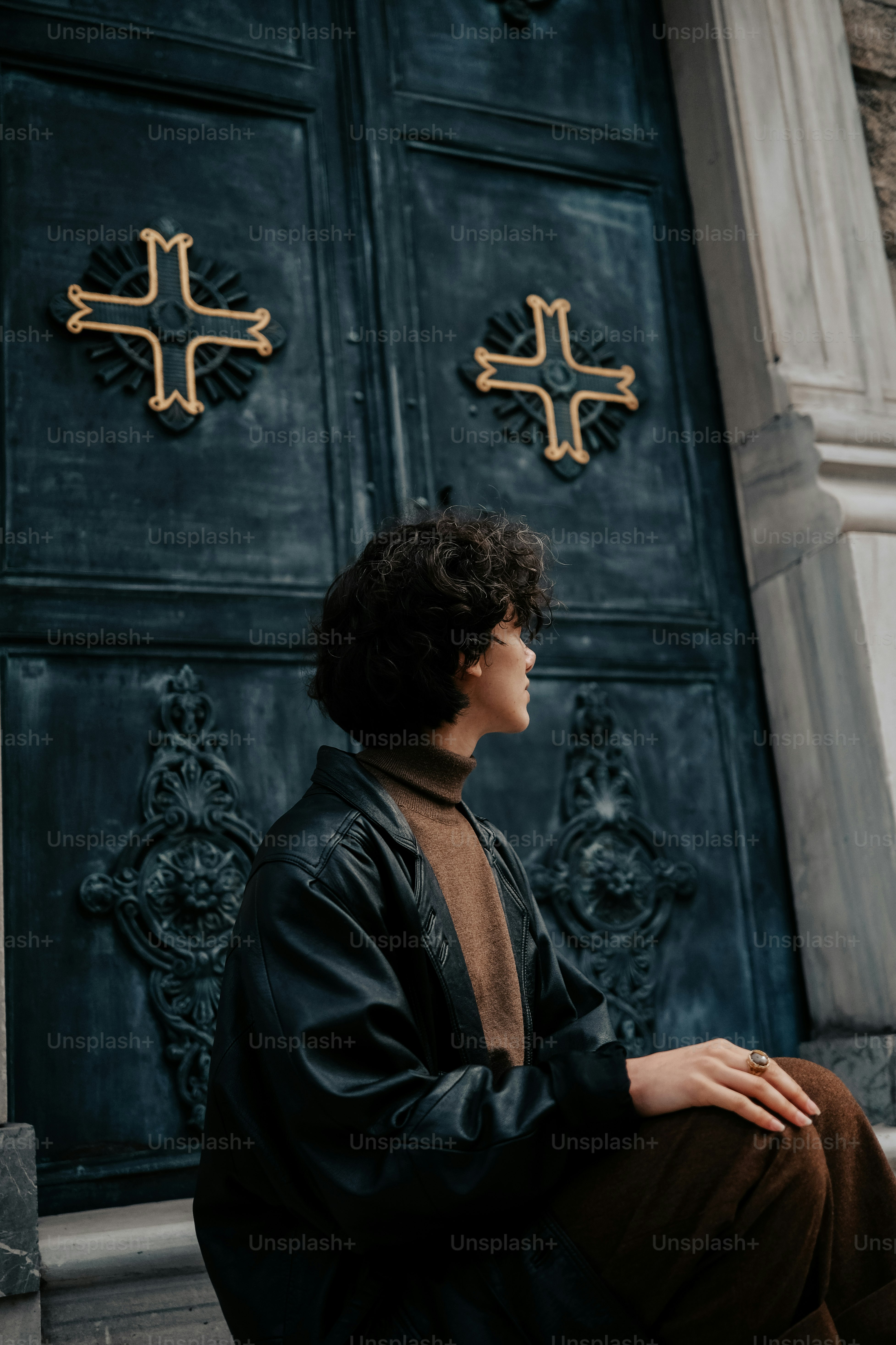 a person sitting on the ground in front of a door