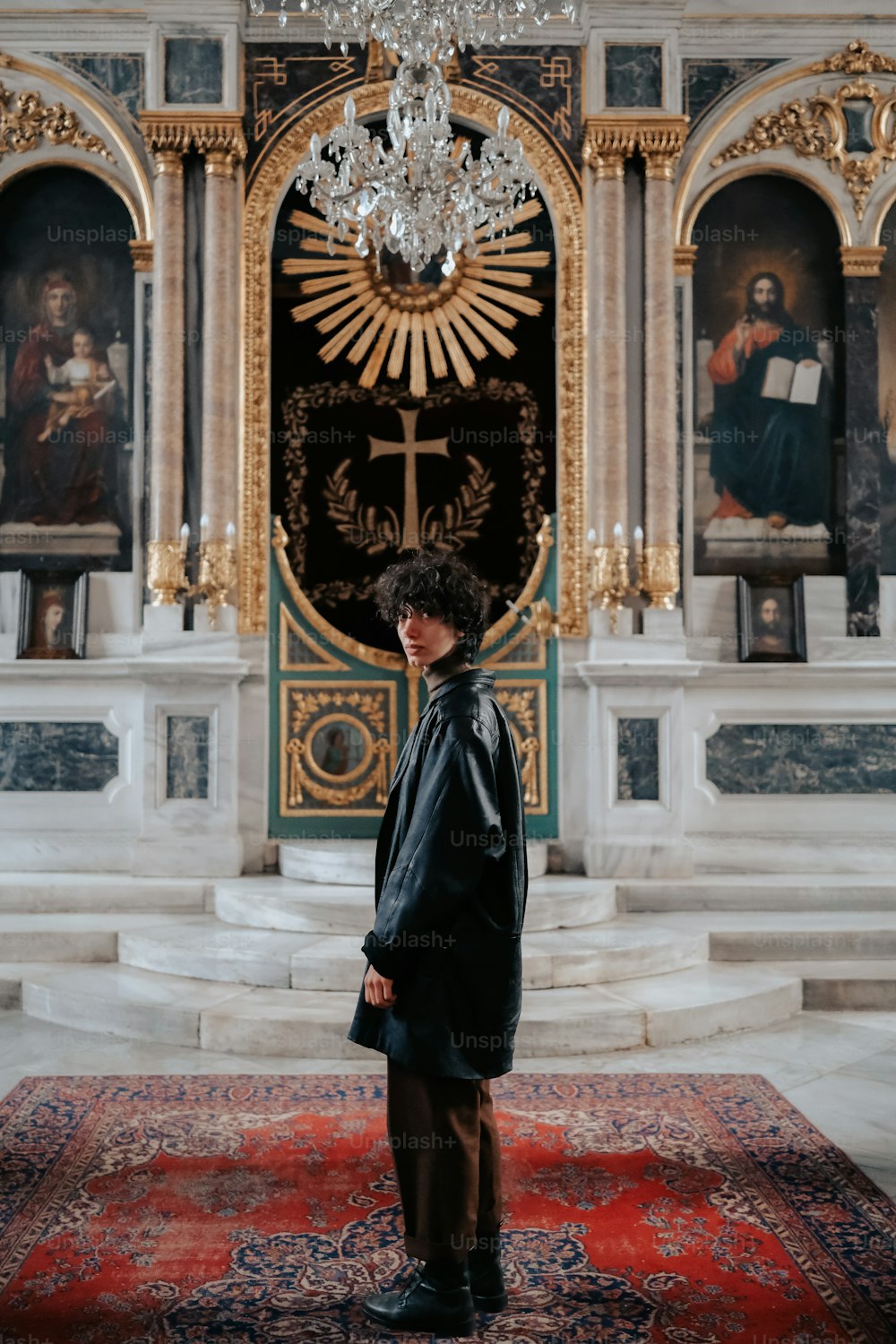 a person standing in a room with a chandelier