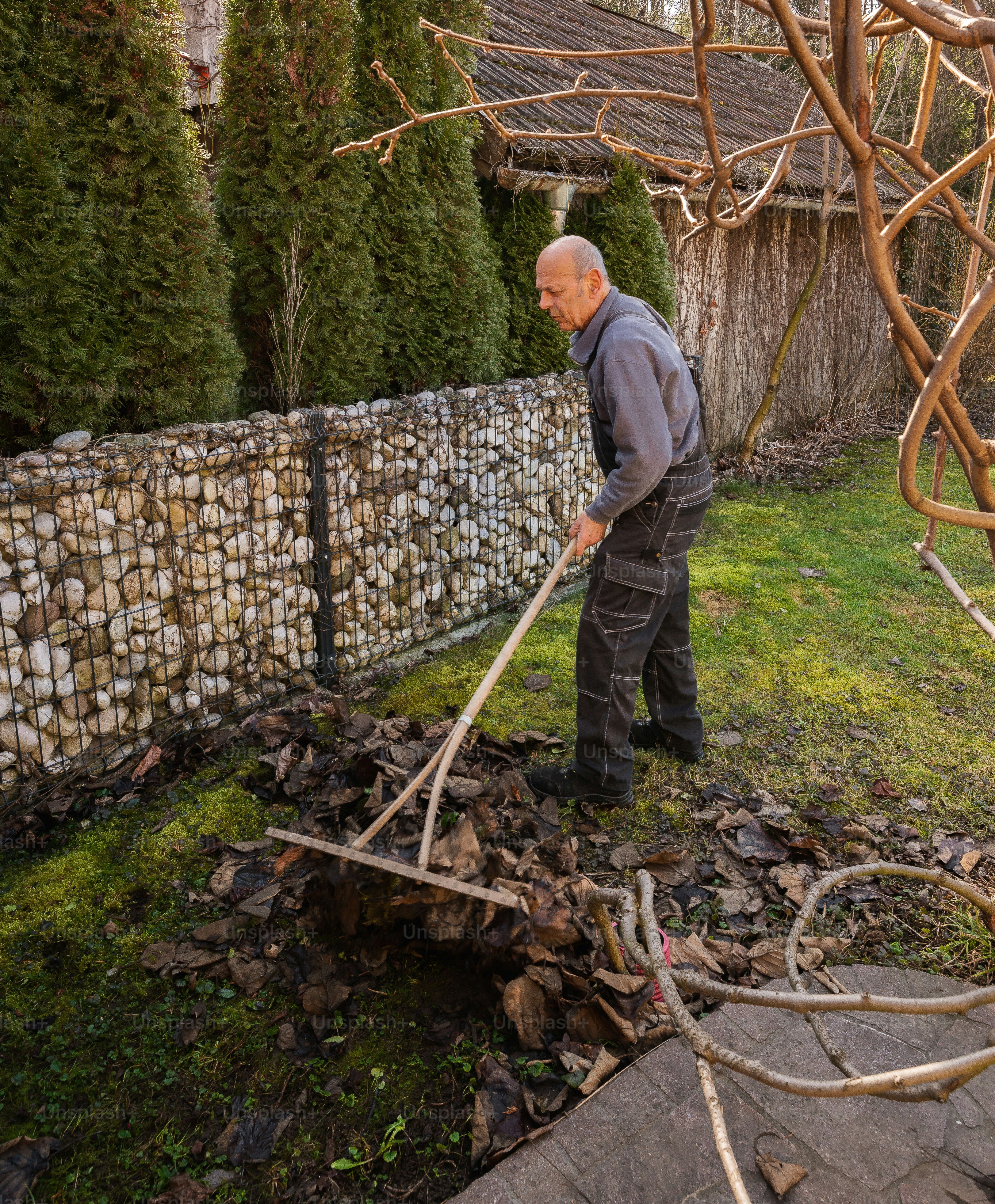 Un hombre está parado en el patio con un palo