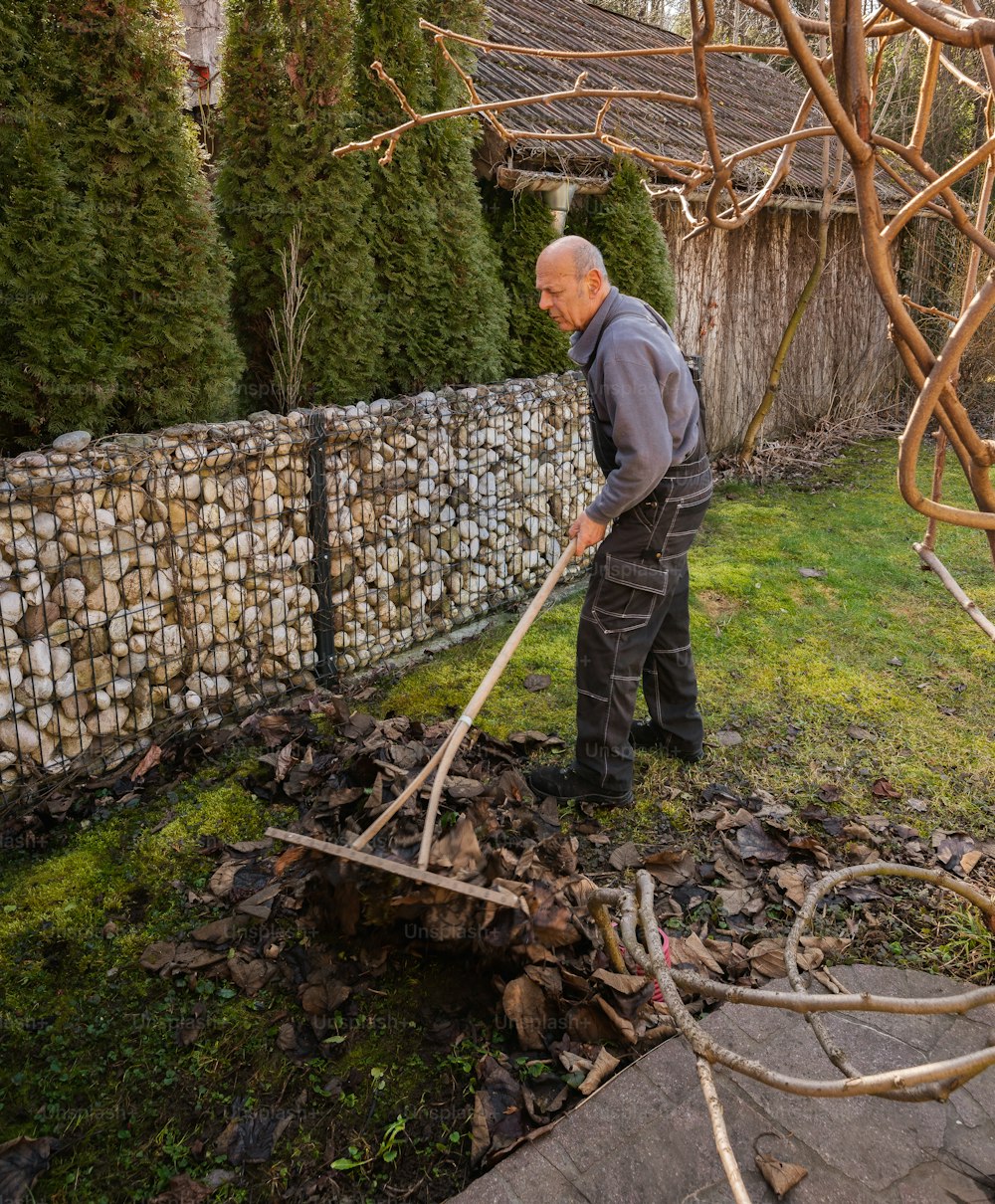 a man is standing in the yard with a stick