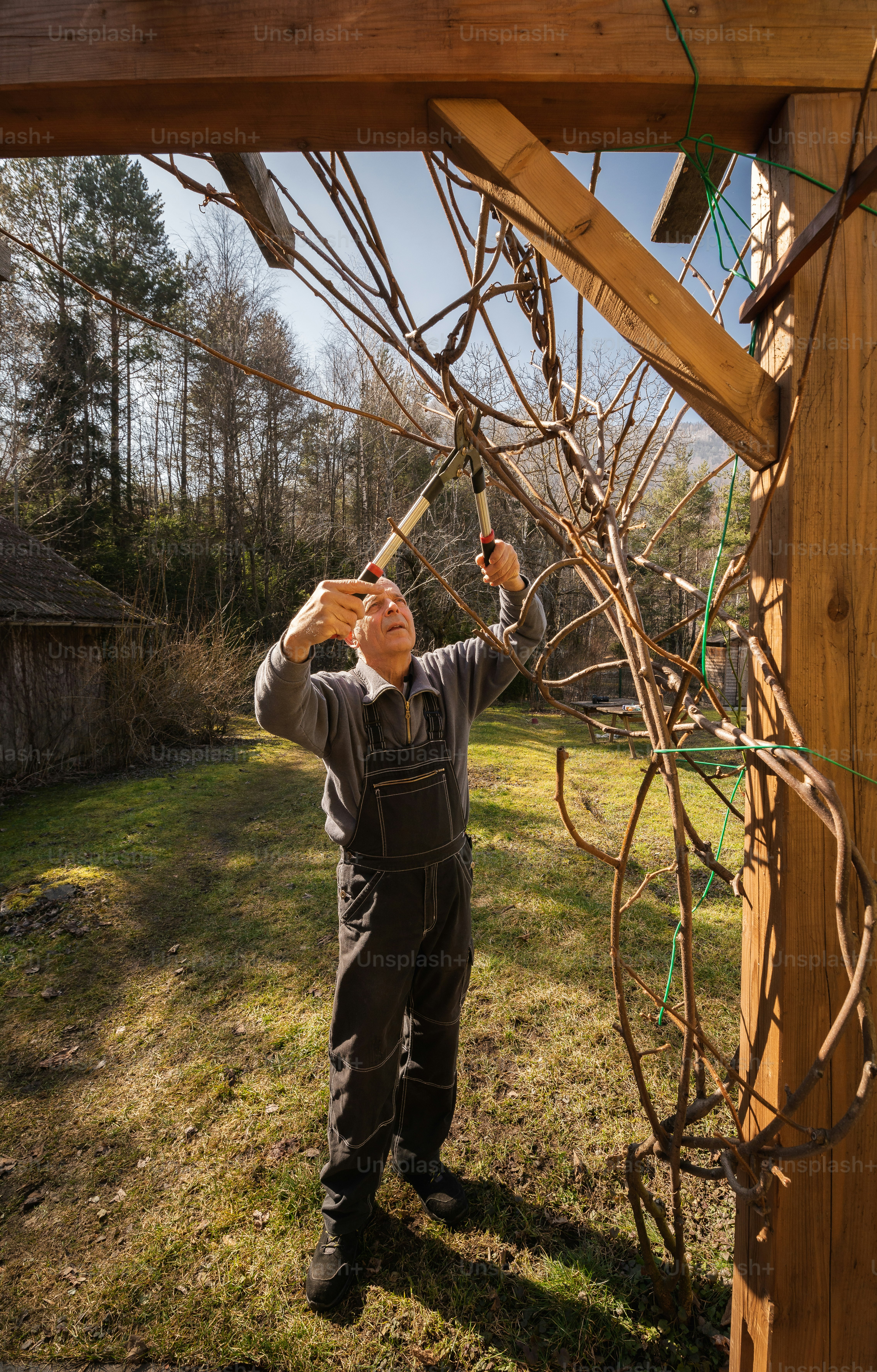 a man in overalls working on a wooden structure