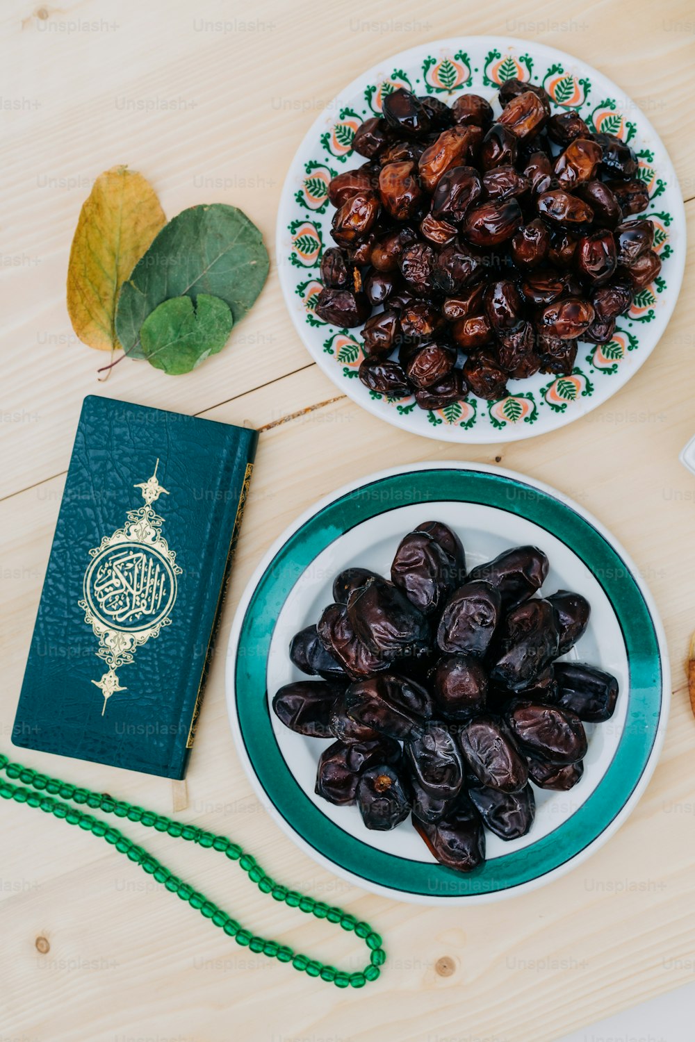 a plate of raisins next to a green book on a table